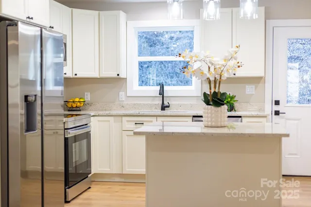 a kitchen with stainless steel appliances granite countertop a refrigerator and a sink
