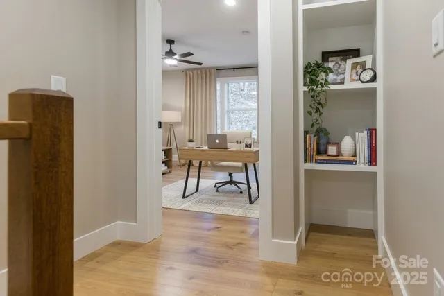 a view of a hallway with dining room and wooden floor