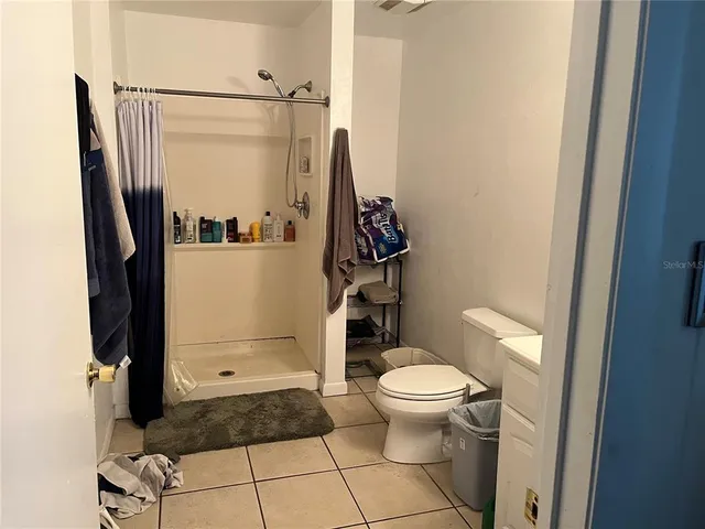 a bathroom with a granite countertop toilet and a shower