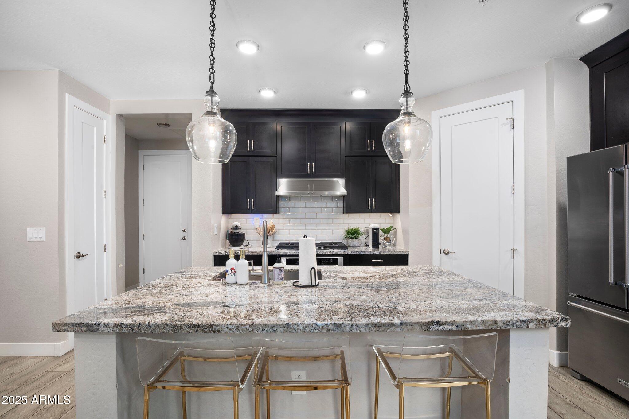 3855 South McQueen Road, Unit 21 Chandler, AZ 85286 - Photo 7 of 35 a kitchen with kitchen island granite countertop a sink and refrigerator