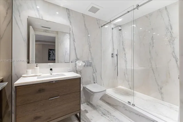 a bathroom with a sink toilet double vanity and shower
