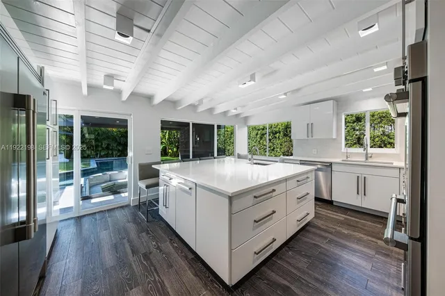 a large white kitchen with a large window