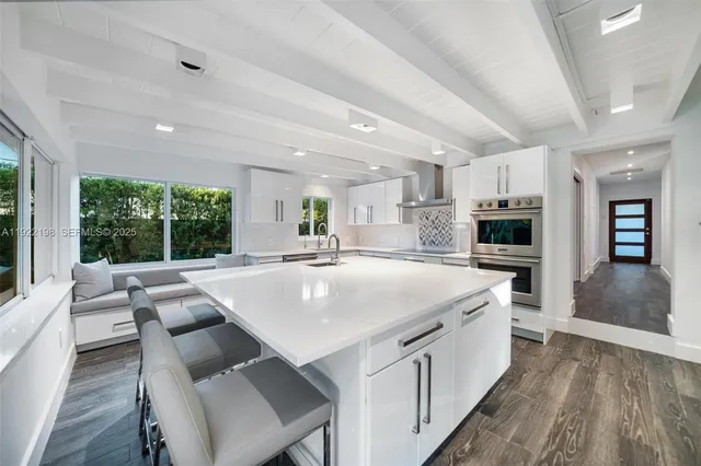 a kitchen with kitchen island a sink a counter top and stainless steel appliances