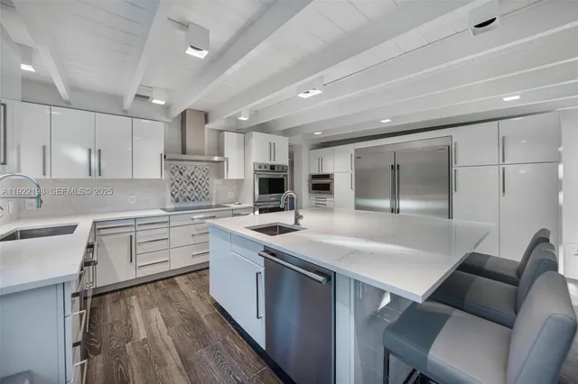 a kitchen with a sink a counter top space stainless steel appliances and cabinets