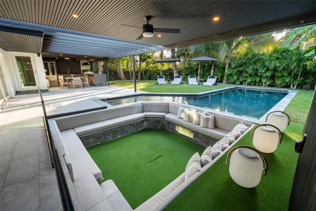 a swimming pool with outdoor seating and yard