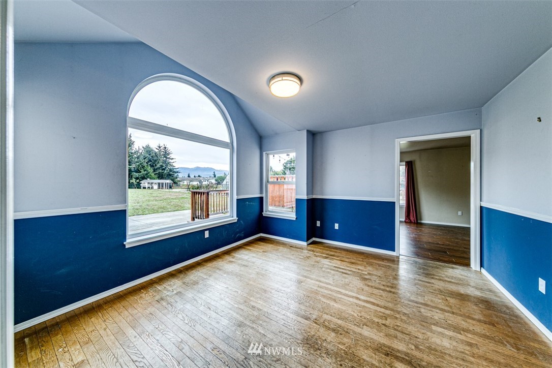 243 Griffith Farm Road Sequim, WA 98382 - Photo 8 of 35 an empty room with wooden floor and windows
