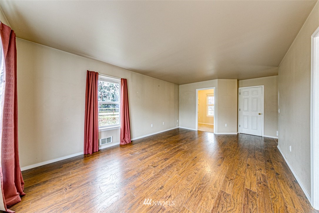 243 Griffith Farm Road Sequim, WA 98382 - Photo 9 of 35 a view of an empty room and window with wooden floor