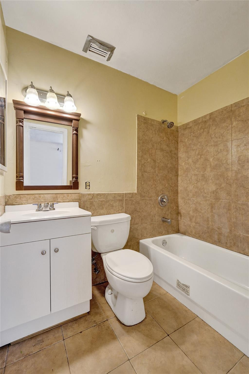 1960 Southwest 68th Way Miramar, FL 33023 - Photo 16 of 39 a bathroom with a toilet a sink a mirror and bathtub