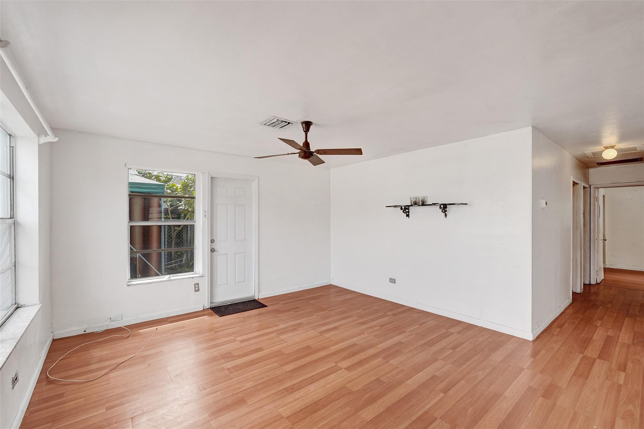 1960 Southwest 68th Way Miramar, FL 33023 - Photo 3 of 39 an empty room with wooden floor cabinet and windows