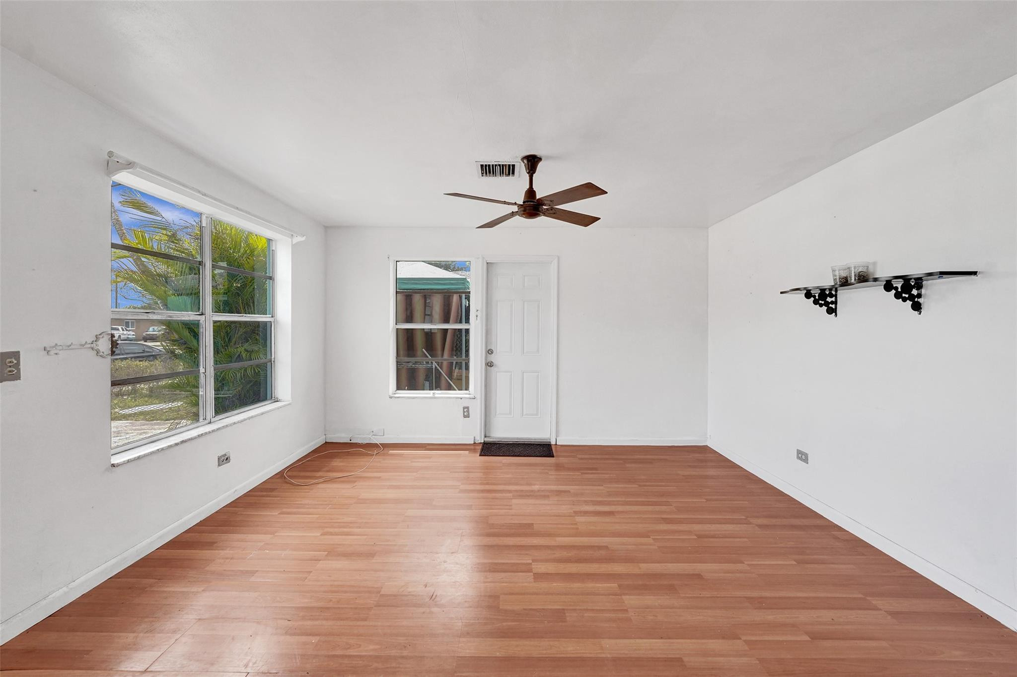1960 Southwest 68th Way Miramar, FL 33023 - Photo 4 of 39 a view of a livingroom with wooden floor a ceiling fan and windows