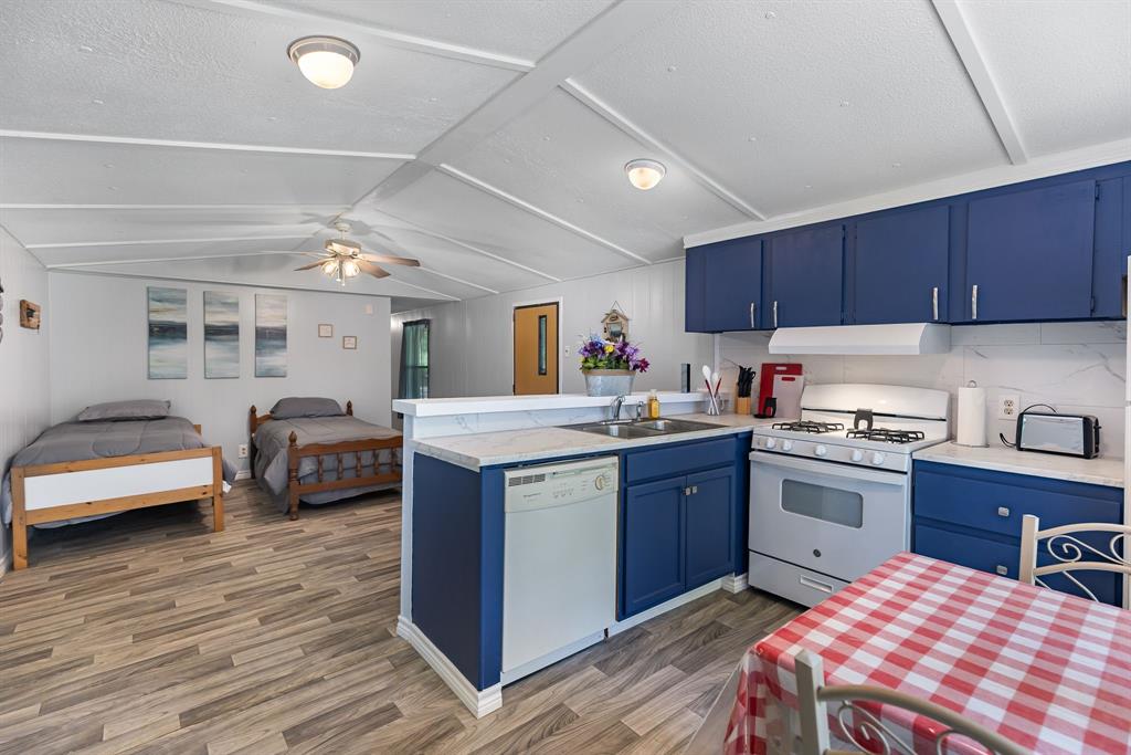 277 Private Road Pittsburg, TX 75686 - Photo 15 of 40 a kitchen with kitchen island granite countertop a sink and wooden cabinets