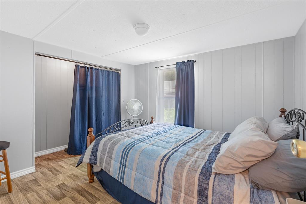 277 Private Road Pittsburg, TX 75686 - Photo 17 of 40 a bedroom with a bed and wooden floor