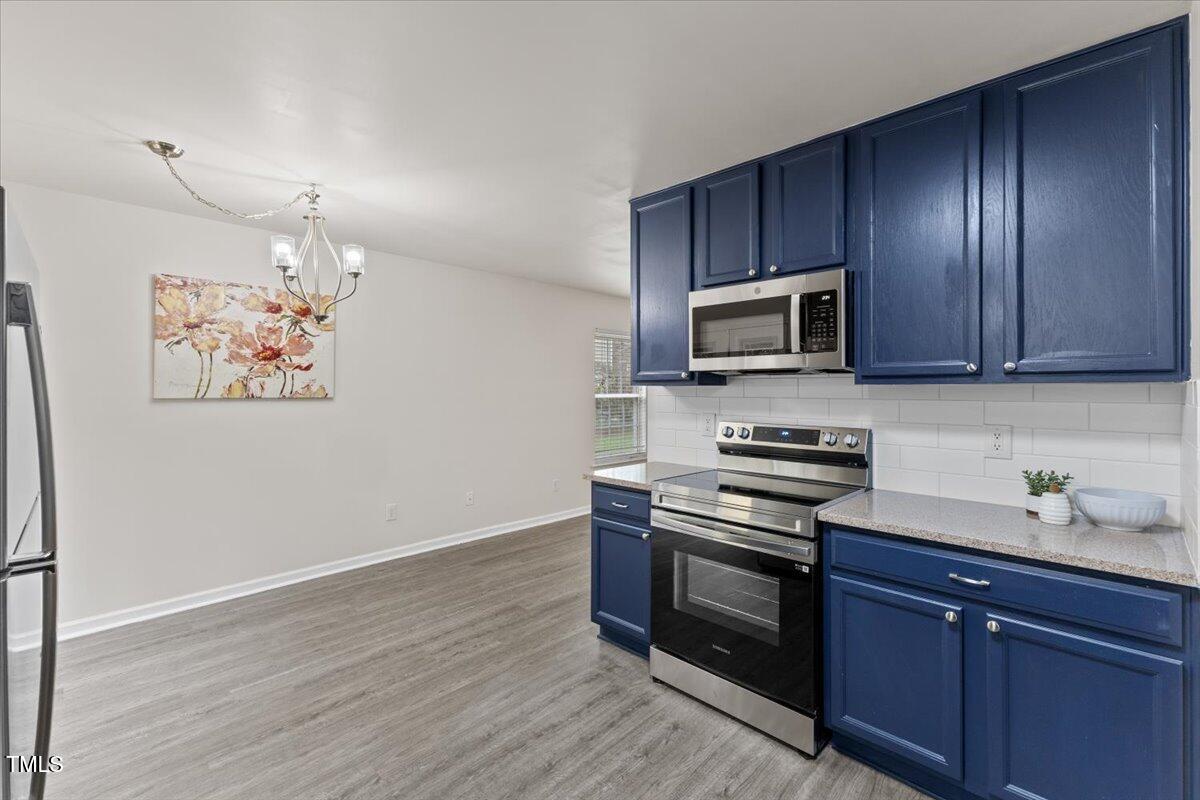315 Inkster Cove Raleigh, NC 27603 - Photo 13 of 44 a kitchen with wooden cabinets and stainless steel appliances