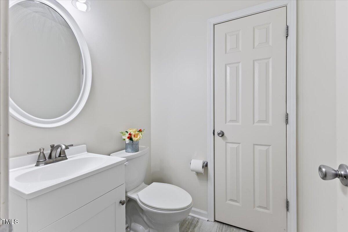 315 Inkster Cove Raleigh, NC 27603 - Photo 22 of 44 a bathroom with a toilet a sink a vanity and mirror