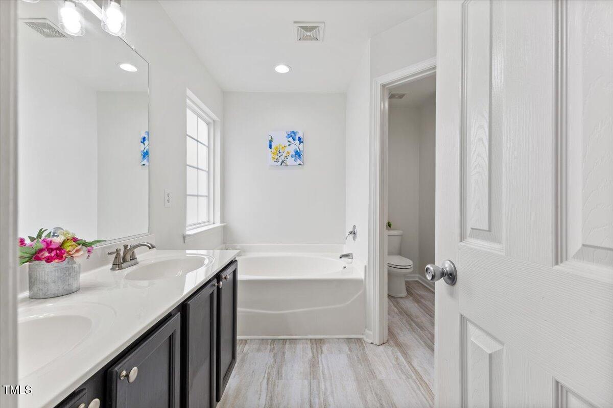 315 Inkster Cove Raleigh, NC 27603 - Photo 32 of 44 a bathroom with a sink mirror and a bathtub