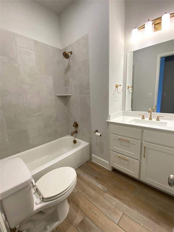 1937 Halkin Road Celina, TX 75009 - Photo 4 of 20 Bathroom featuring a white vanity with a quartz countertop, gold-finish hardware, a full-size mirror, and a coordinating gold-finish light fixture