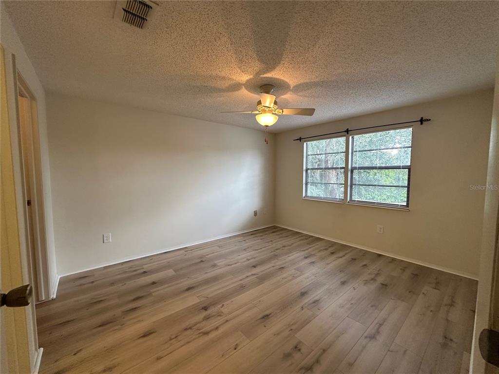 4022 Beaver Lane, Unit 1000H Port Charlotte, FL 33952 - Photo 17 of 24 an empty room with wooden floor fan and windows