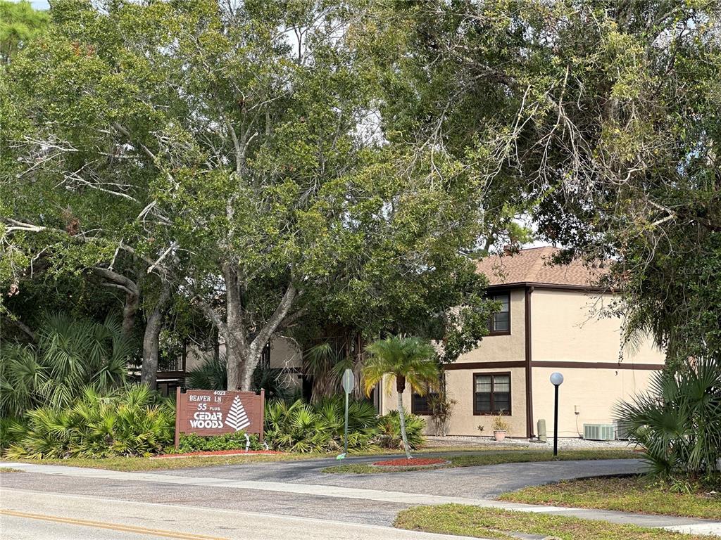 4022 Beaver Lane, Unit 1000H Port Charlotte, FL 33952 - Photo 23 of 24 a view of a white house with a large tree and plants