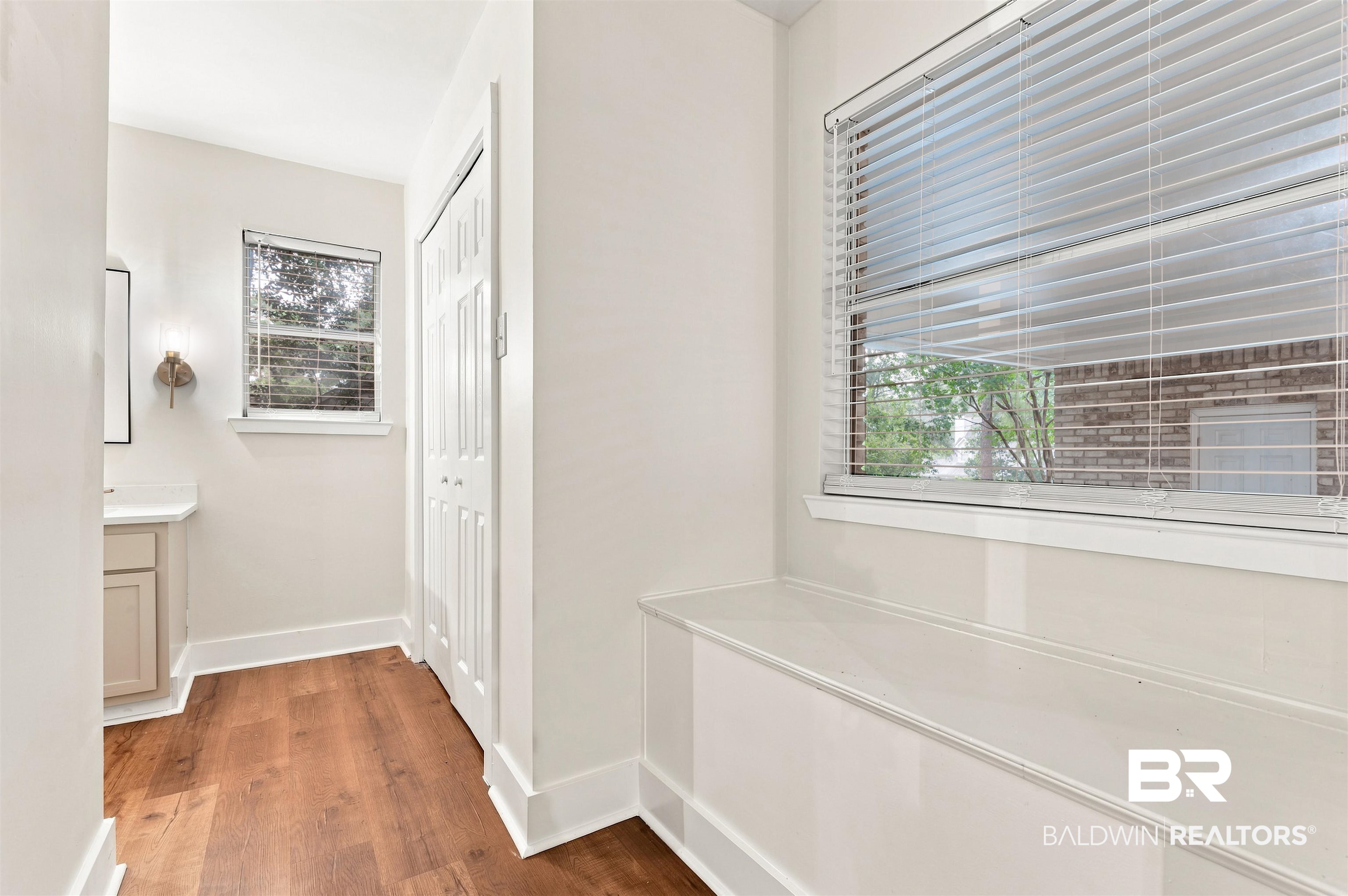 599 Ridgewood Drive Daphne, AL 36526 - Photo 18 of 41 Window-side bench seating with wood-finish flooring, white trim, and a white bi-fold closet door