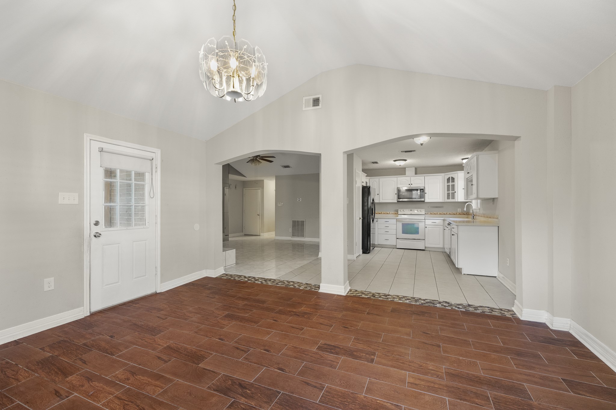 23826 Lestergate Drive Spring, TX 77373 - Photo 11 of 45 Looking back toward the kitchen and living room, the flex room stays connected to the rest of the home through the double arched openings while still feeling like its own destination. With the kitchen just steps away and the backyard door nearby, this space is well set up for entertaining, casual gatherings, or whatever version of “extra room” fits your lifestyle best.