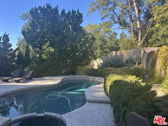 a view of a patio with table and chairs under an umbrella