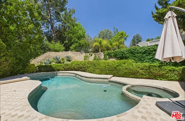 a patio with a table and chairs under an umbrella