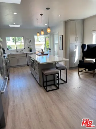 a living room with kitchen furniture and a wooden floor
