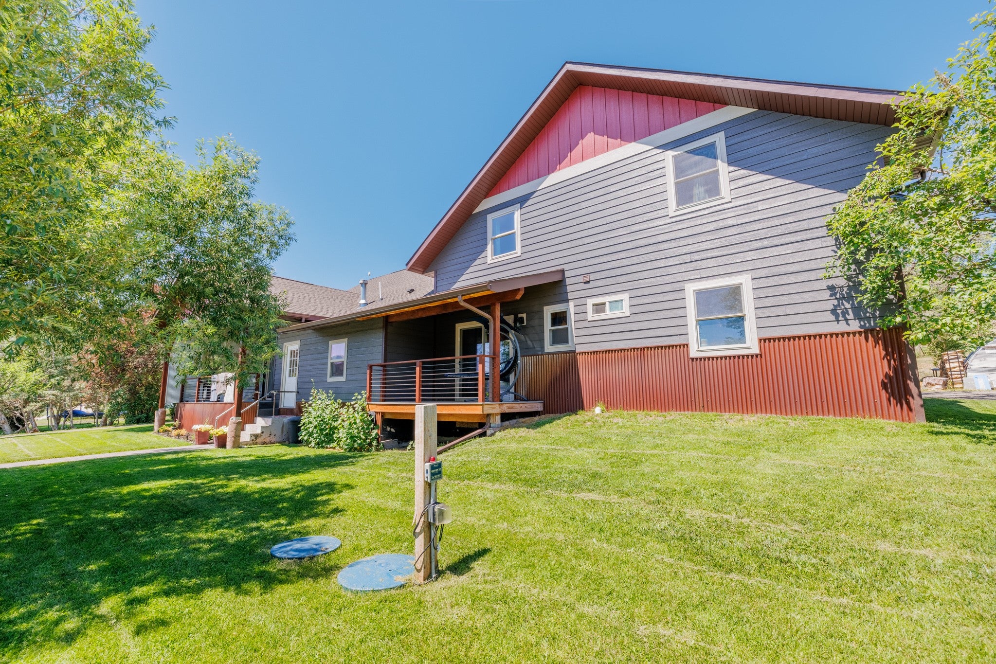 58 Gilman Road Garrison, MT 59731 - Photo 21 of 91 Back of property with a wooden deck and a lawn