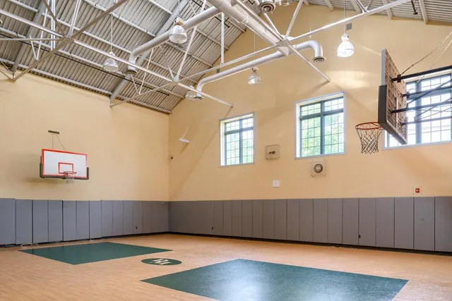 a view of an empty room with wooden floor and a cabinet