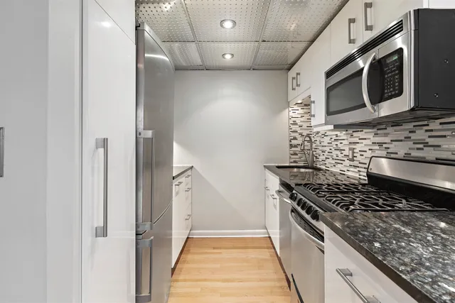 a kitchen with stainless steel appliances granite countertop a stove and a microwave