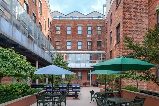 a patio with a table and chairs under an umbrella