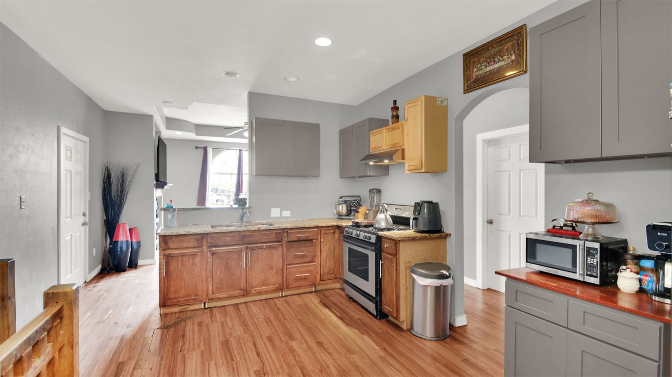 120 Rio Vista Ranch Road Dale, TX 78616 - Photo 7 of 22 a kitchen with stainless steel appliances granite countertop hardwood floor sink stove and wooden cabinets