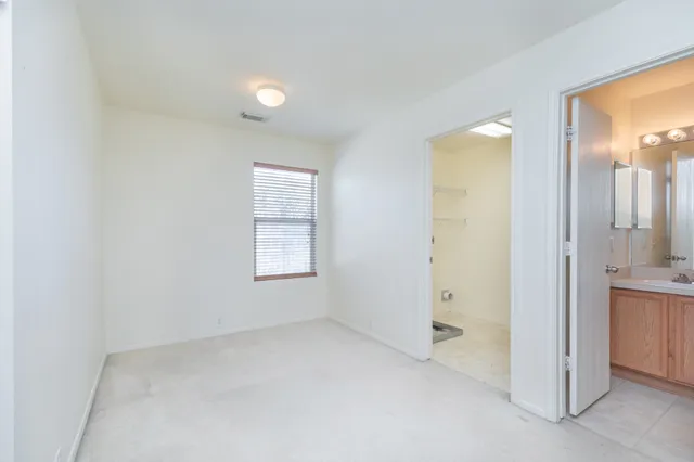 an empty room with a bathroom and a sink