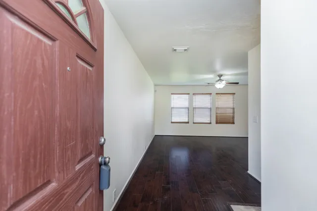 a view of a hallway with wooden floor and a window