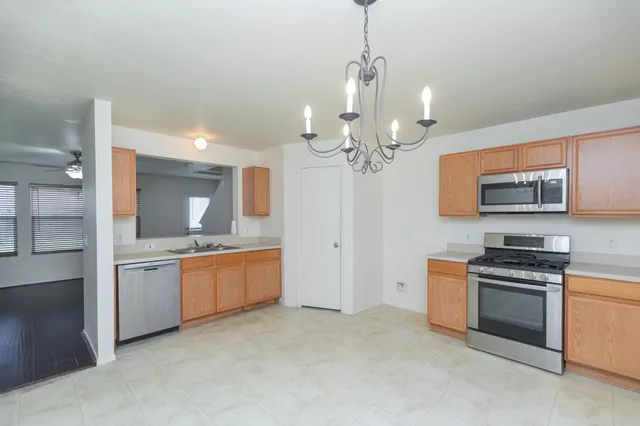 a large kitchen with stainless steel appliances granite countertop a lot of counter space and wooden floor