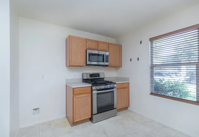 a kitchen with stainless steel appliances granite countertop a stove a sink and a microwave