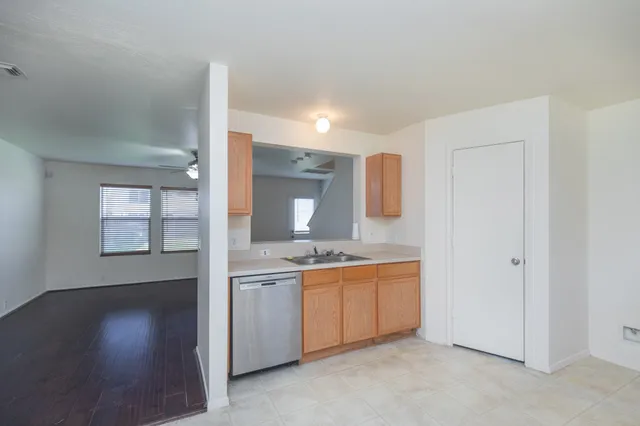 a view of a kitchen with a sink and dishwasher cabinet with wooden floor
