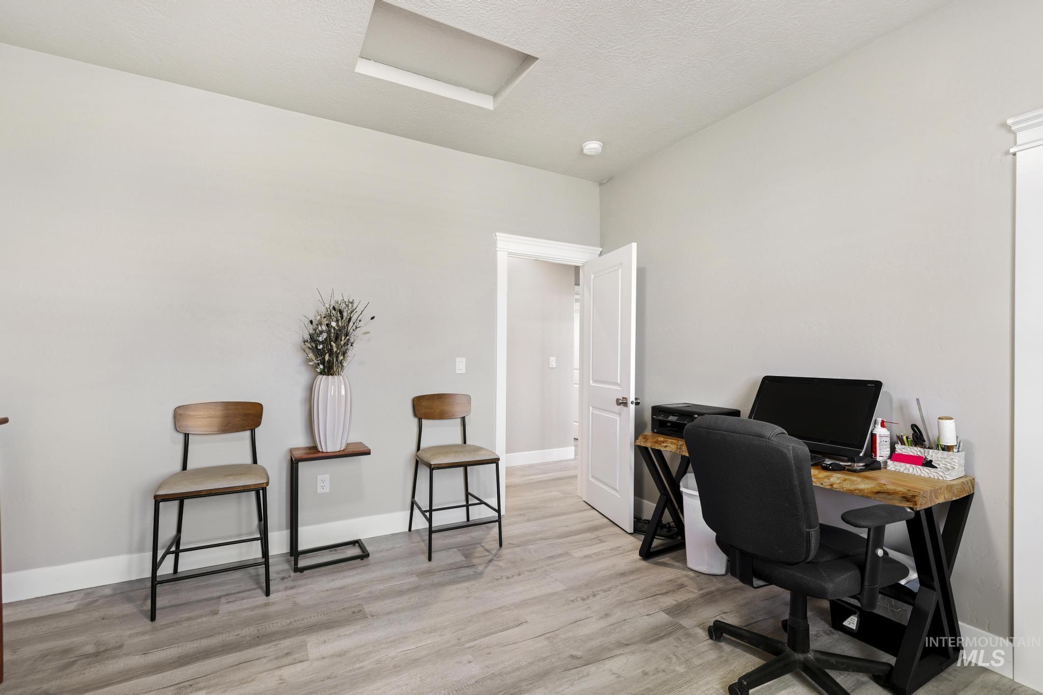 758 Cedar Crk Road Rogerson, ID 83302 - Photo 14 of 50 Spacious room featuring light gray walls, wood-finish flooring, and a white door with brushed nickel hardware