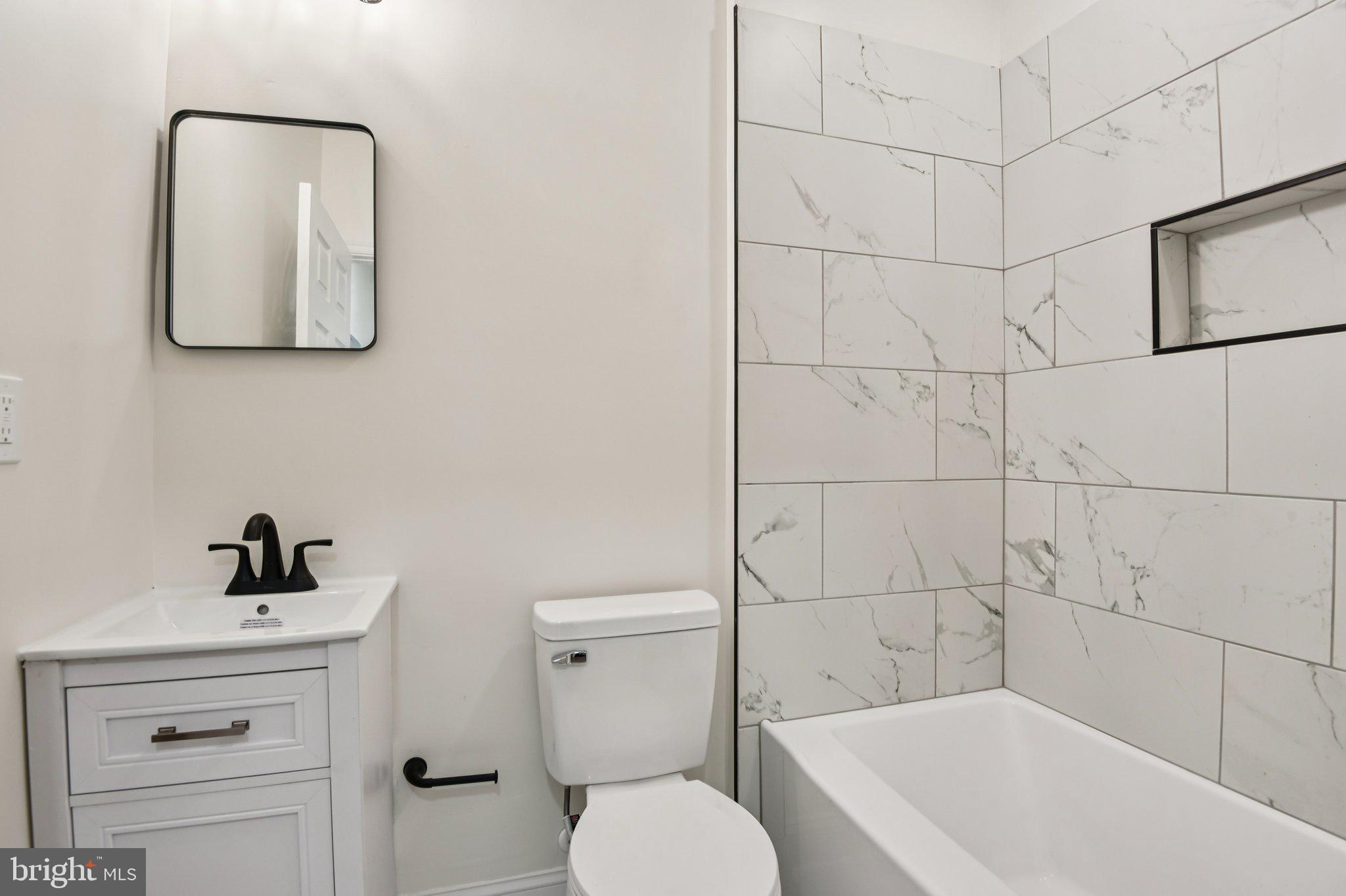 2223 Roslyn Avenue Baltimore, MD 21216 - Photo 16 of 32 a bathroom with a toilet a sink a mirror and vanity
