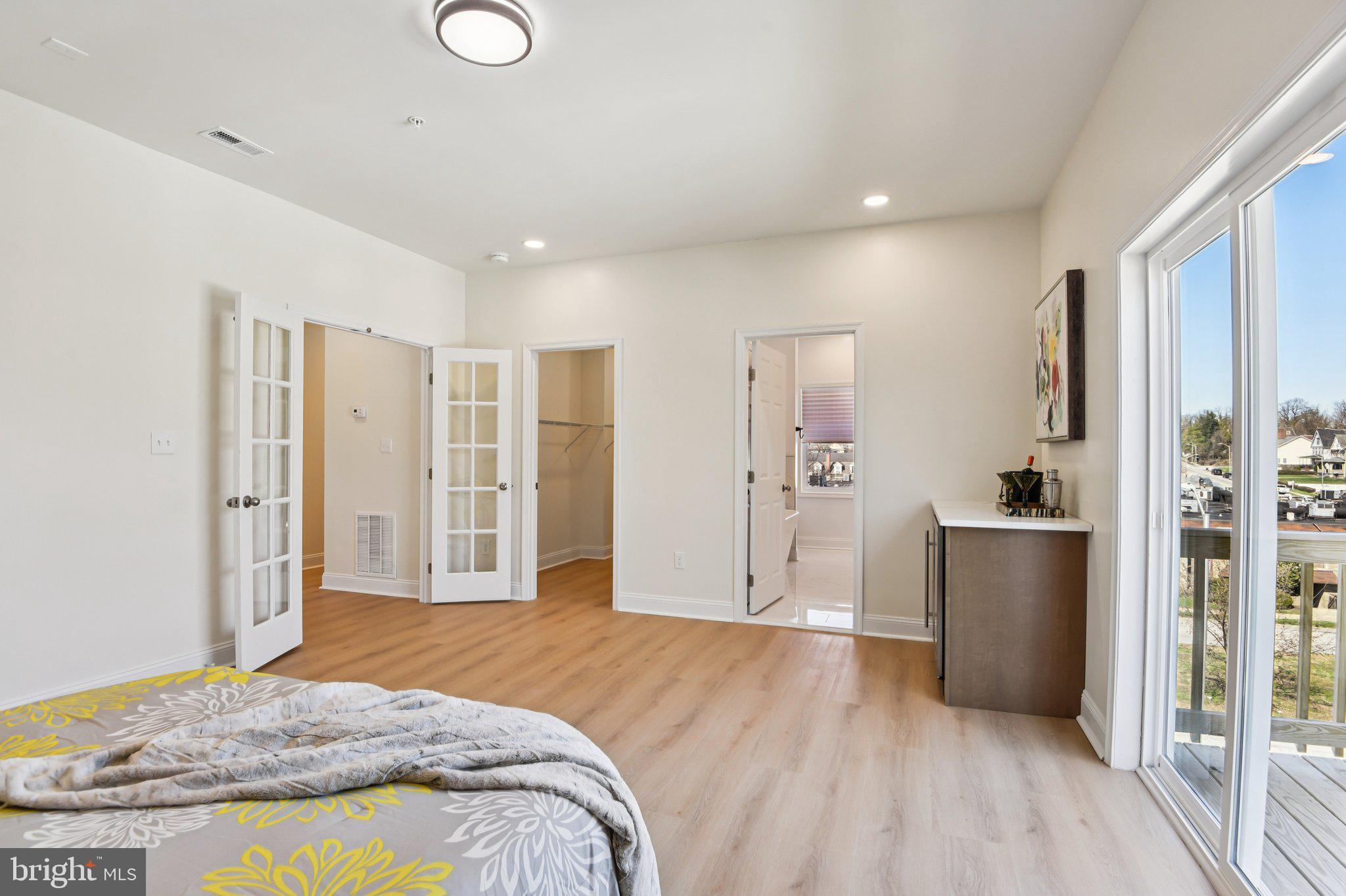 2223 Roslyn Avenue Baltimore, MD 21216 - Photo 24 of 32 a spacious bedroom with a bed and a dresser with wooden floor
