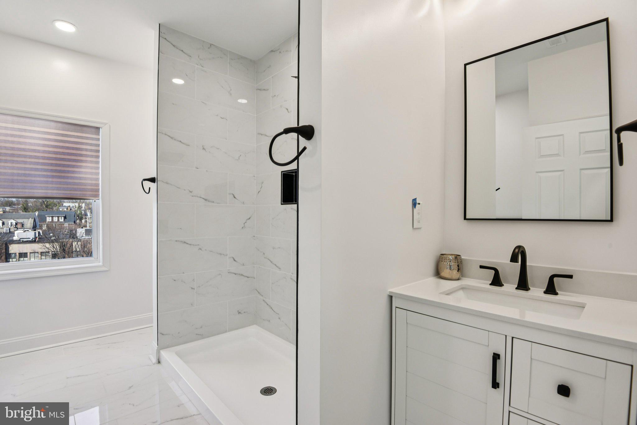 2223 Roslyn Avenue Baltimore, MD 21216 - Photo 25 of 32 a bathroom with a shower sink and mirror