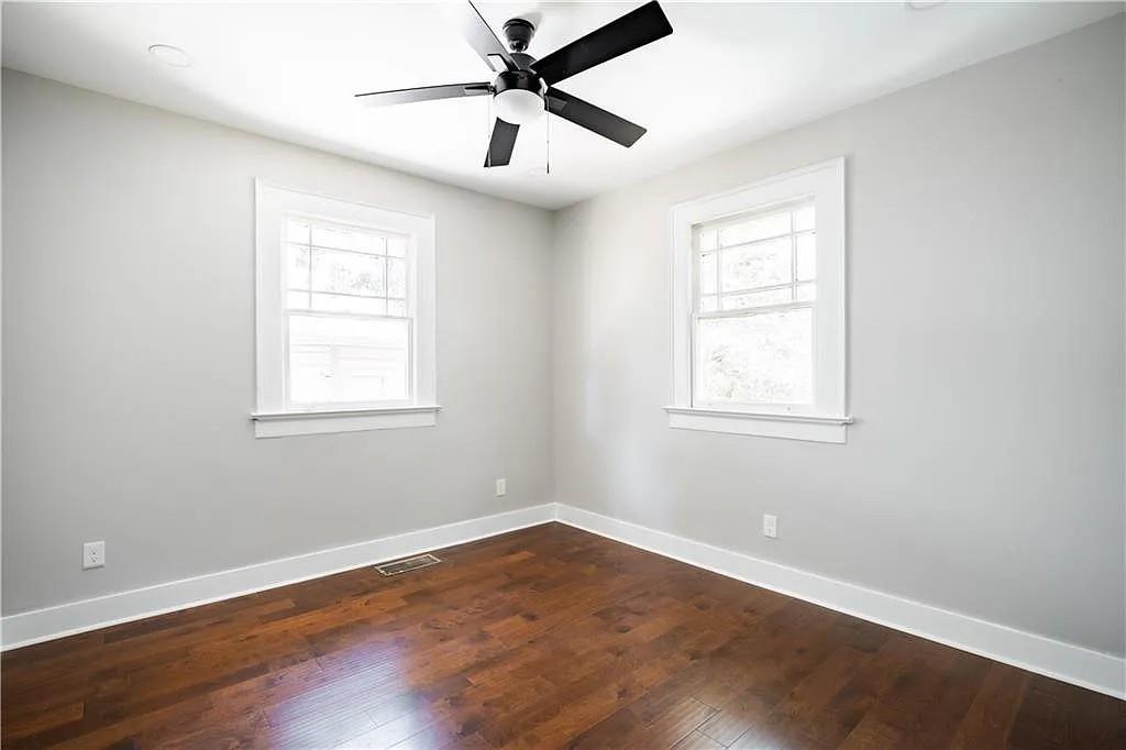 943 Rose Circle Southwest Atlanta, GA 30310 - Photo 15 of 33 an empty room with wooden floor ceiling fan and windows