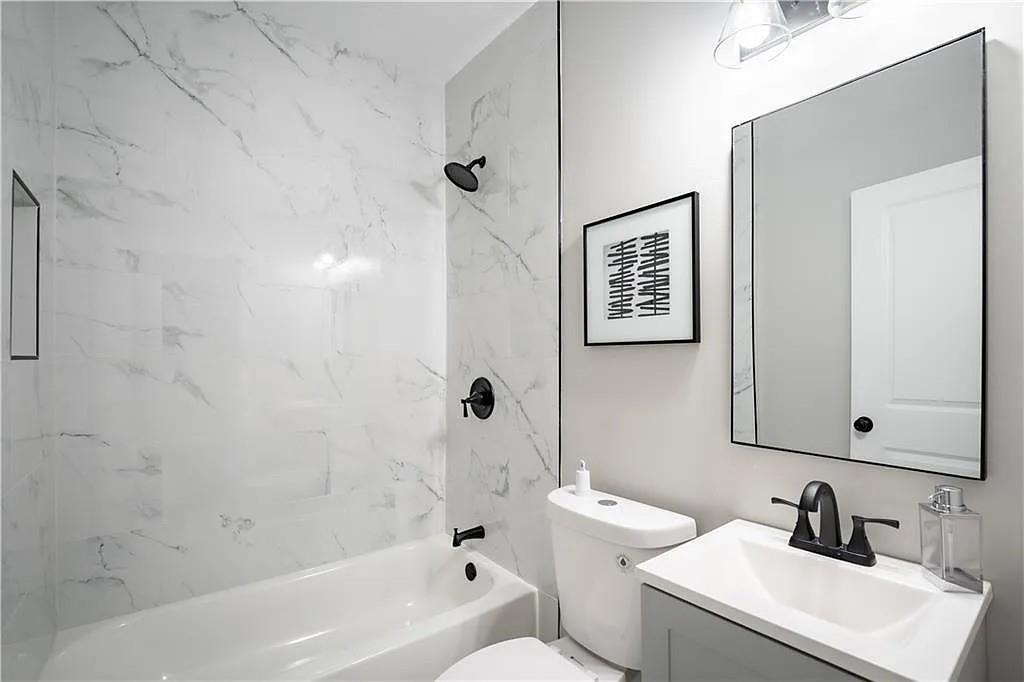 943 Rose Circle Southwest Atlanta, GA 30310 - Photo 18 of 33 a bathroom with a sink a toilet and shower