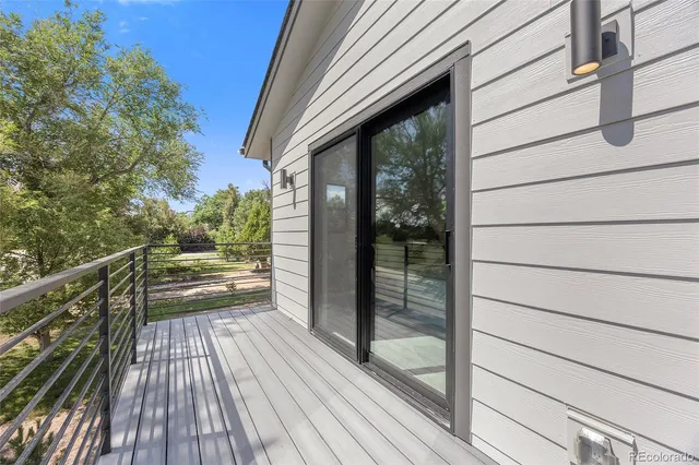 a view of balcony with wooden floor and floor to ceiling window