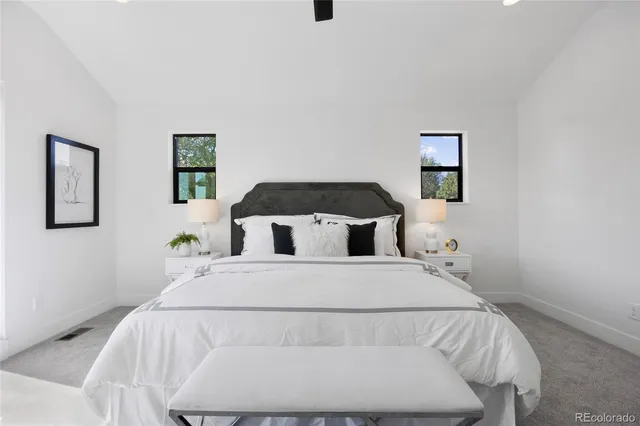 a bedroom with a bed and painting on the wall