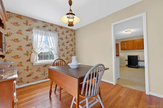 a dining room with furniture a chandelier and wooden floor
