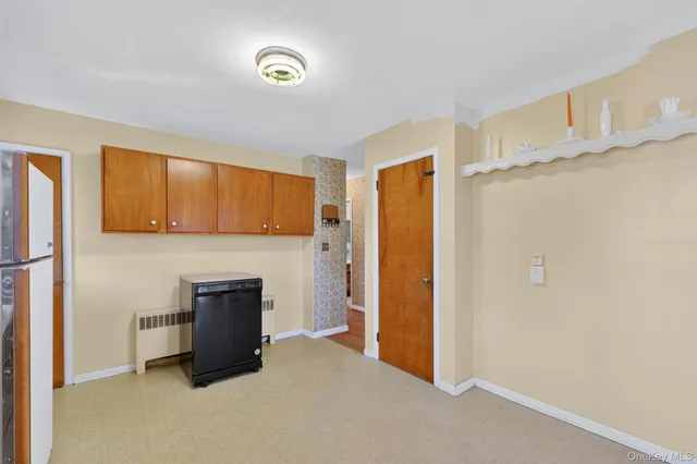 a view of kitchen with refrigerator cabinets and entryway