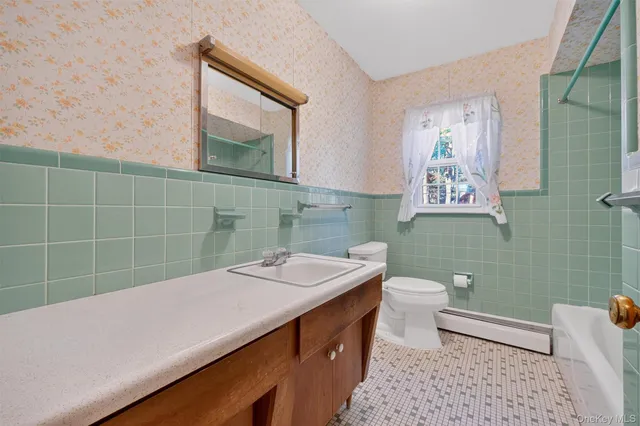 a bathroom with a sink a toilet a mirror and shower