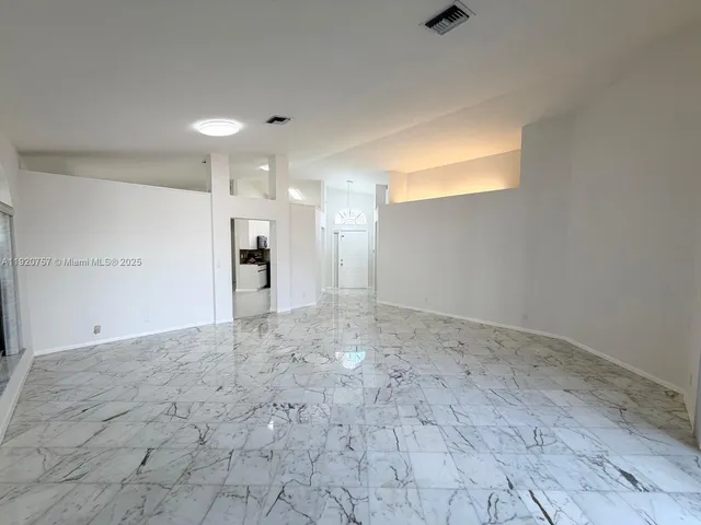 a view of a big room with wooden cabinet and windows