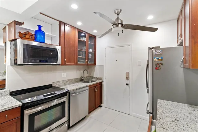 a kitchen with stainless steel appliances granite countertop a refrigerator and a stove top oven